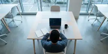 Vista aérea de uma pessoa concentrada em um notebook e caderno, em uma mesa minimalista com padrões geométricos, simbolizando o desafio do foco em meio à sobrecarga digital.